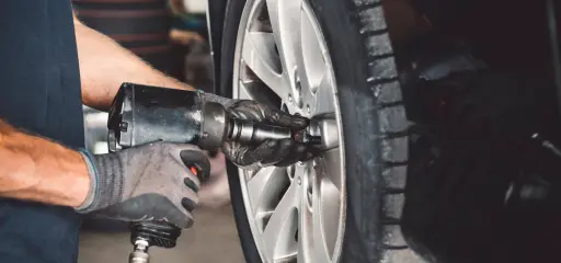 Person changing a car tire.
